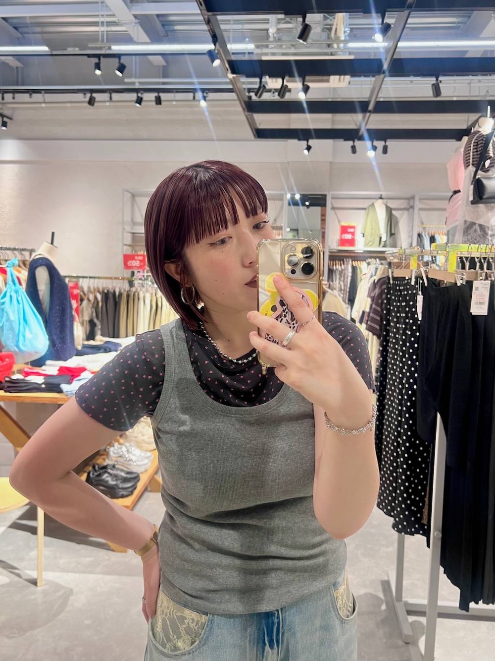 グレー系のタンクトップ、ブルー系のデニムパンツ、ブラック系のローファーを着用したレディースの夏コーディネートの3枚目の写真