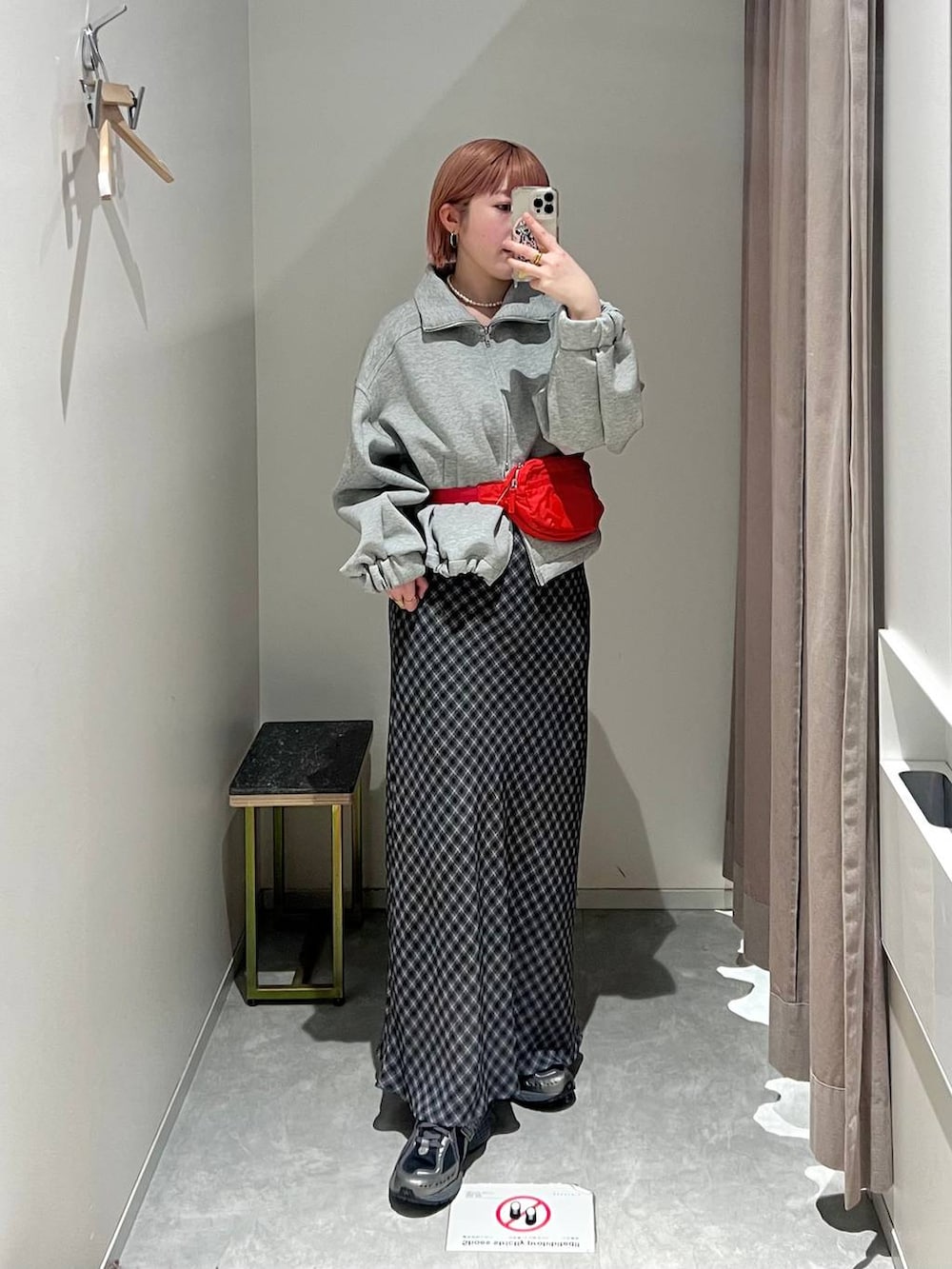 レッド系のボディバッグ/ウエストポーチ、グレー系のスカート、グレー系のスウェットを着用したレディースの冬コーディネートの2枚目の写真