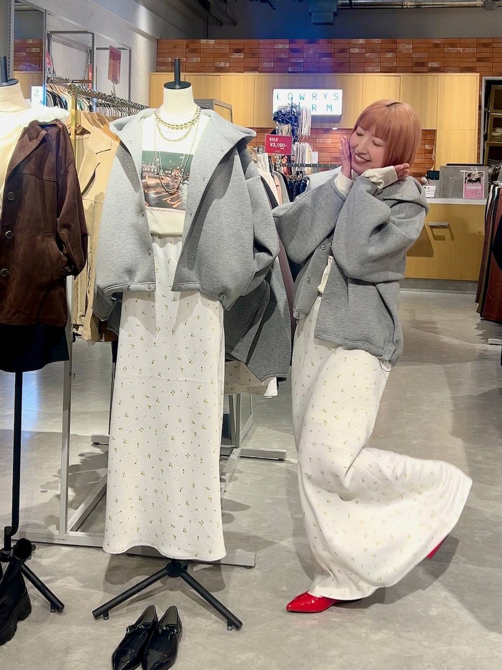 ホワイト系のスカート、レッド系のパンプス、グレー系のブルゾンを着用したレディースの冬コーディネートの2枚目の写真