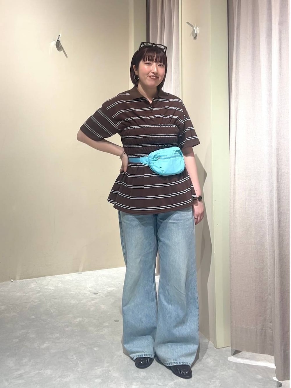 ブルー系のデニムパンツ、ブルー系のボディバッグ/ウエストポーチ、ブラウン系のローファーを着用したレディースの春コーディネートの9枚目の写真