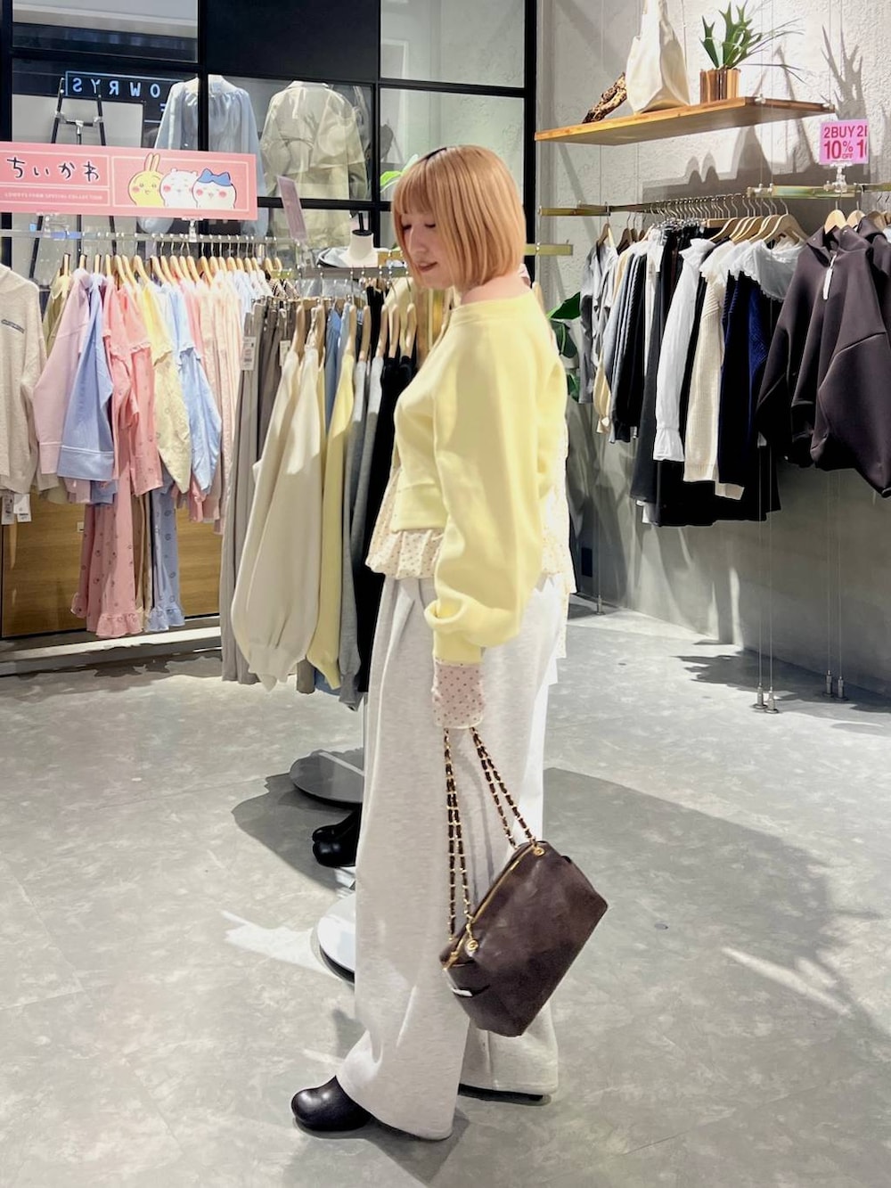 グレー系のスウェットパンツ、ブラウン系のショルダーバッグ、ブラウン系のサンダルを着用したレディースの冬コーディネートの4枚目の写真