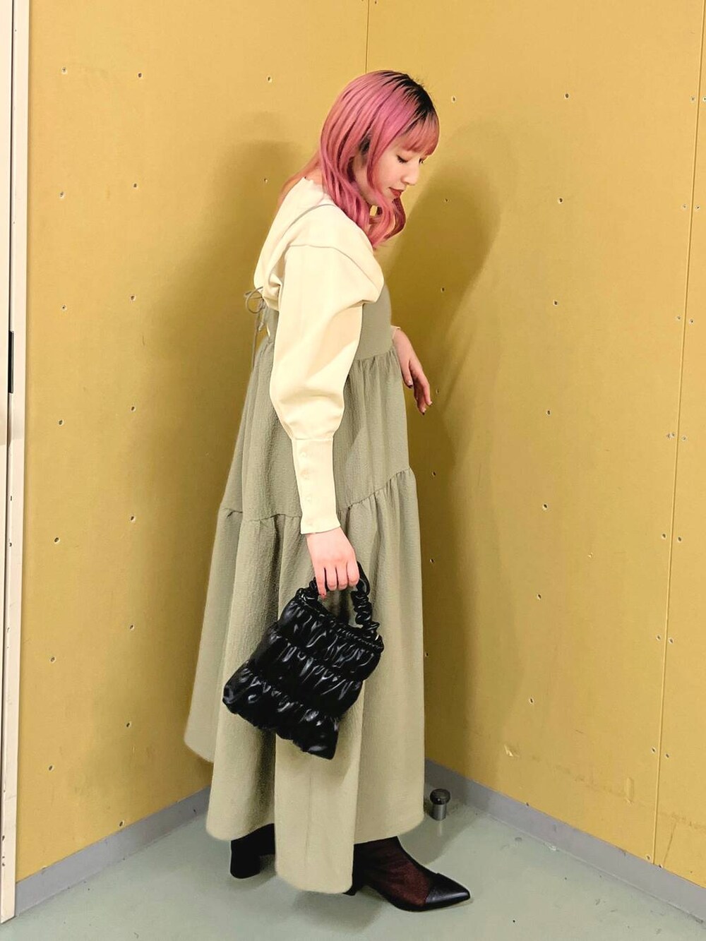 ブラック系のブーツ、ホワイト系のニット/セーター、ブラック系のショルダーバッグを着用したレディースの冬コーディネートの2枚目の写真