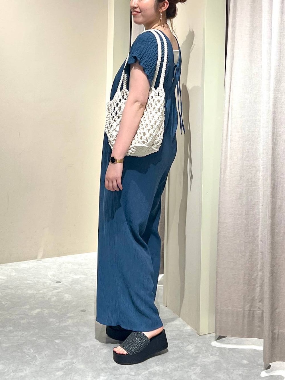 ブラック系のサンダル、ホワイト系のトートバッグ、シルバー系のタンクトップを着用したレディースの夏コーディネートの2枚目の写真