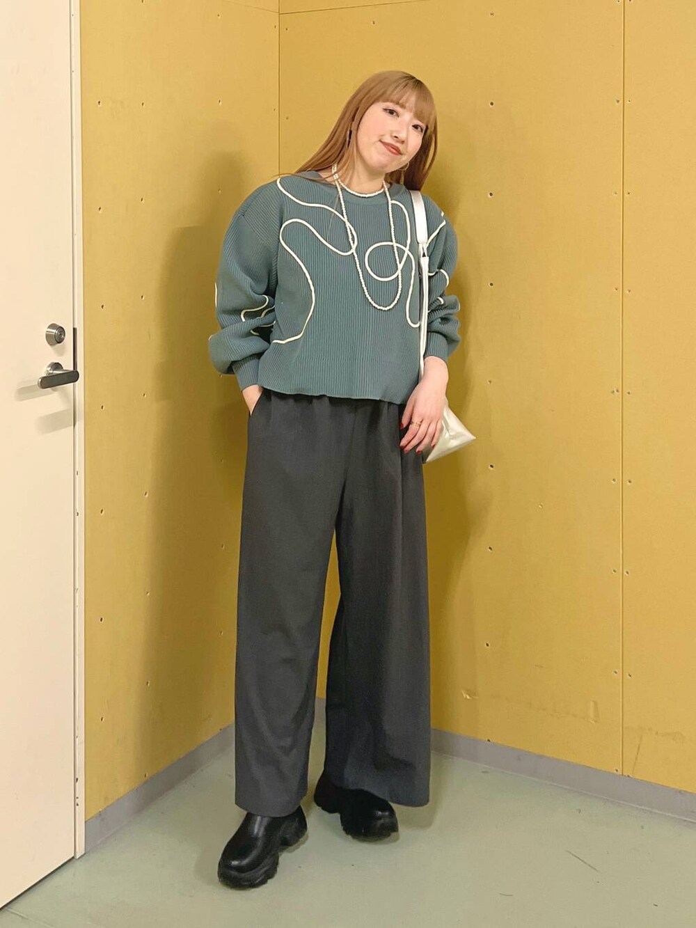 ブラック系のブーツ、シルバー系のトートバッグ、グレー系のその他パンツを着用したレディースの冬コーディネートの4枚目の写真