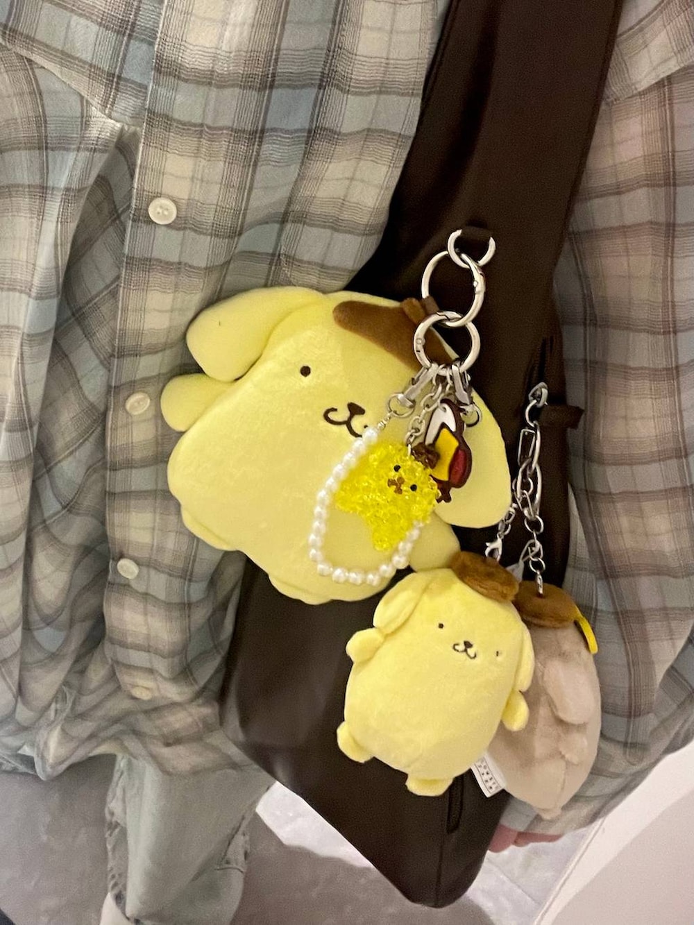 ブルー系のデニムパンツ、イエロー系のエコバッグ/サブバッグ、ブラウン系のショルダーバッグを着用したレディースの春コーディネートの4枚目の写真