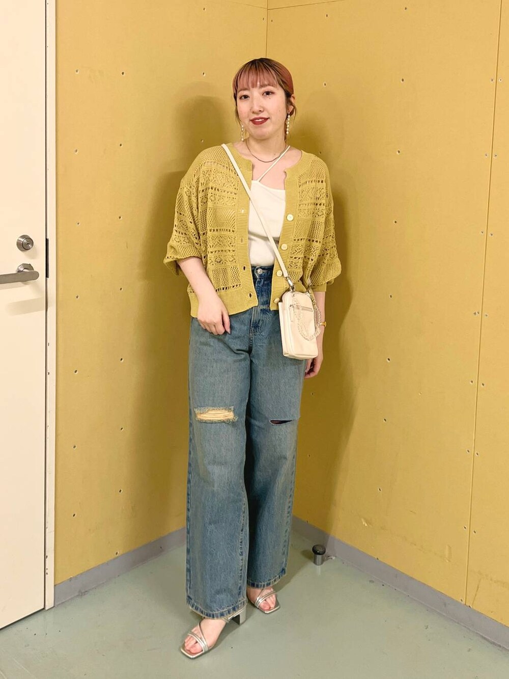 ベージュ系のショルダーバッグ、イエロー系のカーディガン/ボレロ、シルバー系のサンダルを着用したレディースの夏コーディネートの5枚目の写真