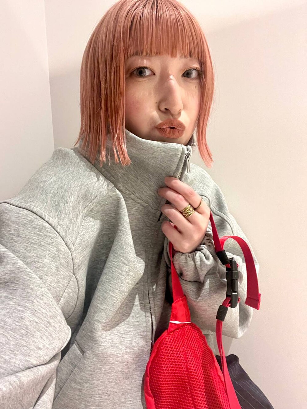 ブルー系のその他パンツ、レッド系のボディバッグ/ウエストポーチ、グレー系のスウェットを着用したレディースの春コーディネートの2枚目の写真