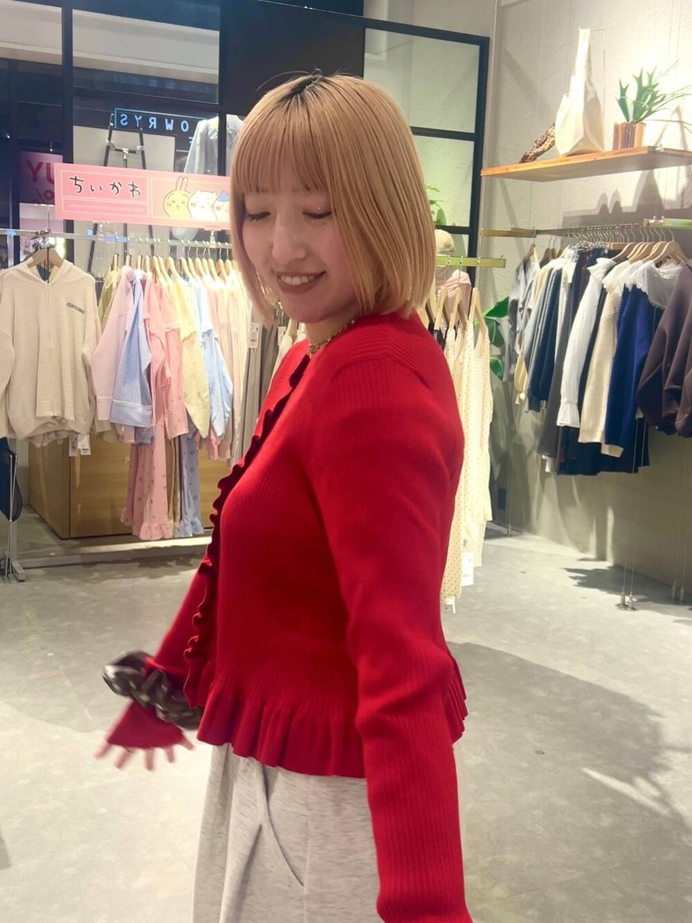 グレー系のスウェットパンツ、レッド系のTシャツ/カットソー、ブラウン系のヘアゴムを着用したレディースの冬コーディネートの2枚目の写真