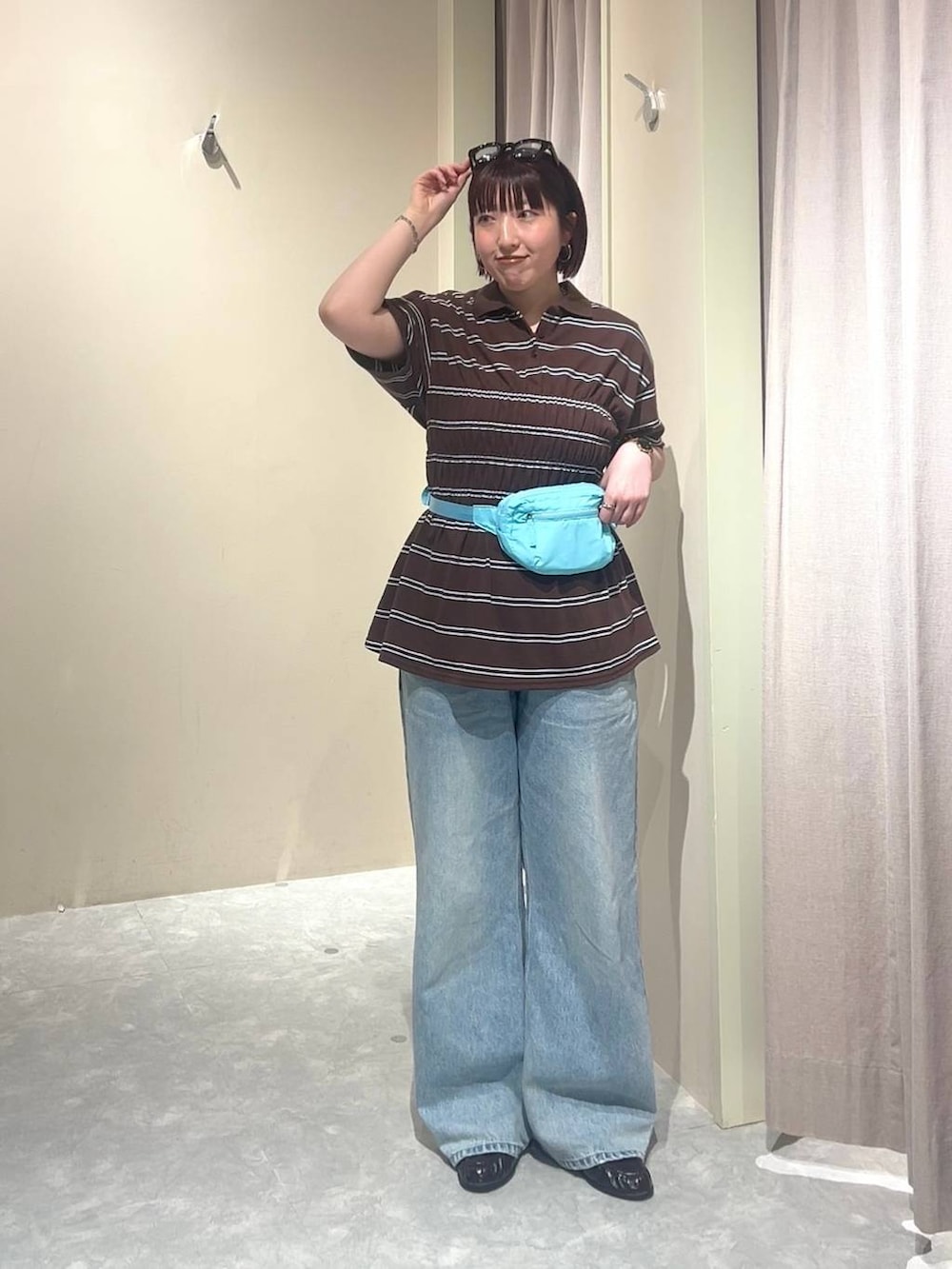 ブルー系のデニムパンツ、ブルー系のボディバッグ/ウエストポーチ、ブラウン系のローファーを着用したレディースの春コーディネートの7枚目の写真