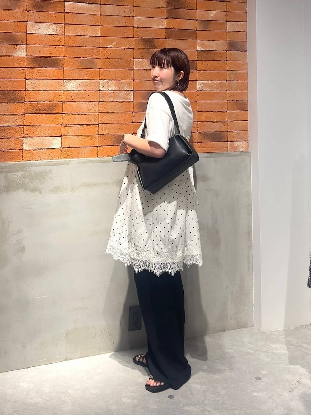 ブラック系のサンダル、ブラック系のその他パンツ、ブラック系のショルダーバッグを着用したレディースの夏コーディネートの2枚目の写真