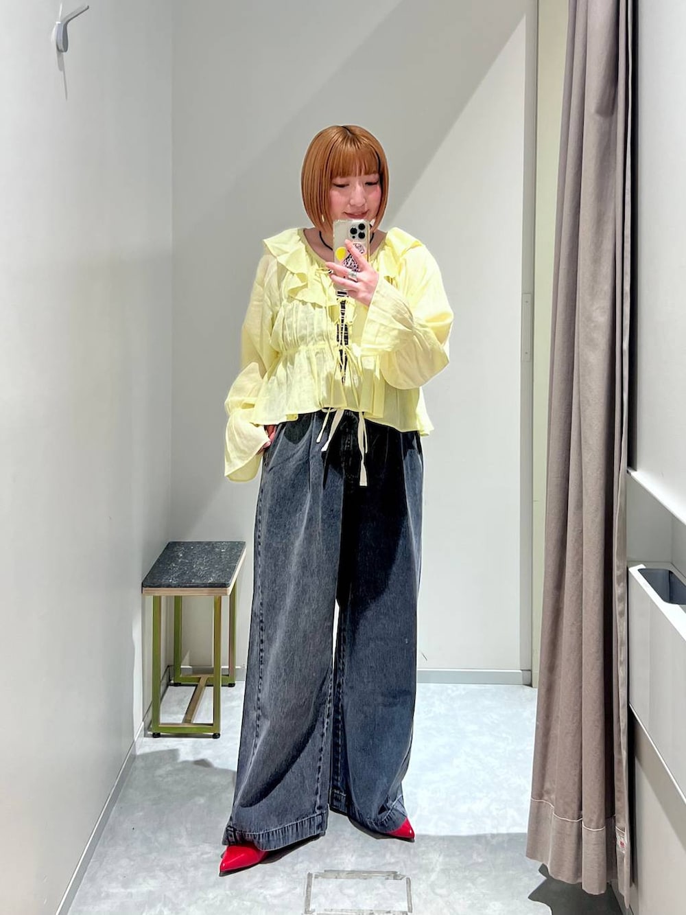 レッド系のパンプス、ブラック系のデニムパンツ、ブラウン系のタンクトップを着用したレディースの春コーディネートの5枚目の写真