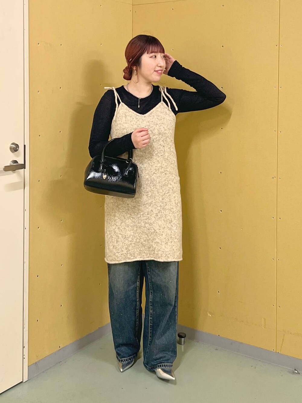 シルバー系のパンプス、ブルー系のデニムパンツ、ブラック系のTシャツ/カットソーを着用したレディースの秋コーディネートの3枚目の写真