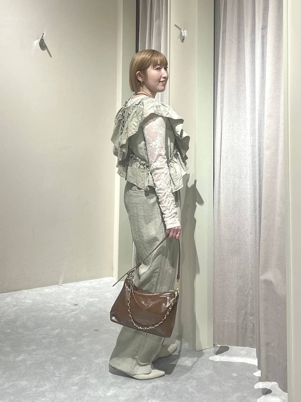 ブラウン系のショルダーバッグ、ホワイト系のパンプス、ホワイト系のTシャツ/カットソーを着用したレディースの春コーディネートの2枚目の写真