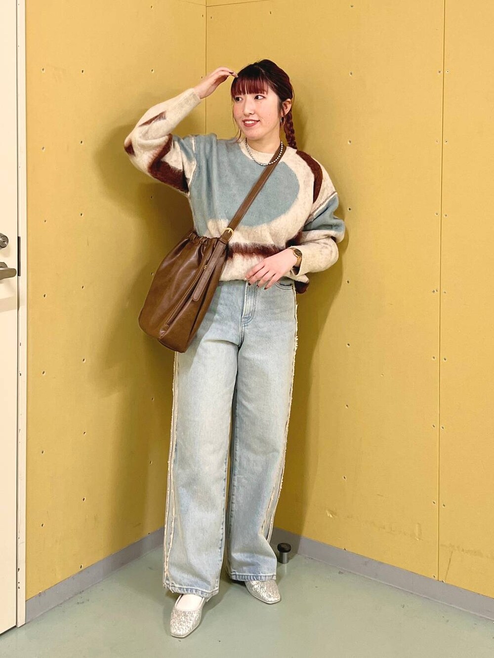 シルバー系のパンプス、ホワイト系のニット/セーター、ブラウン系のショルダーバッグを着用したレディースの秋コーディネートの3枚目の写真