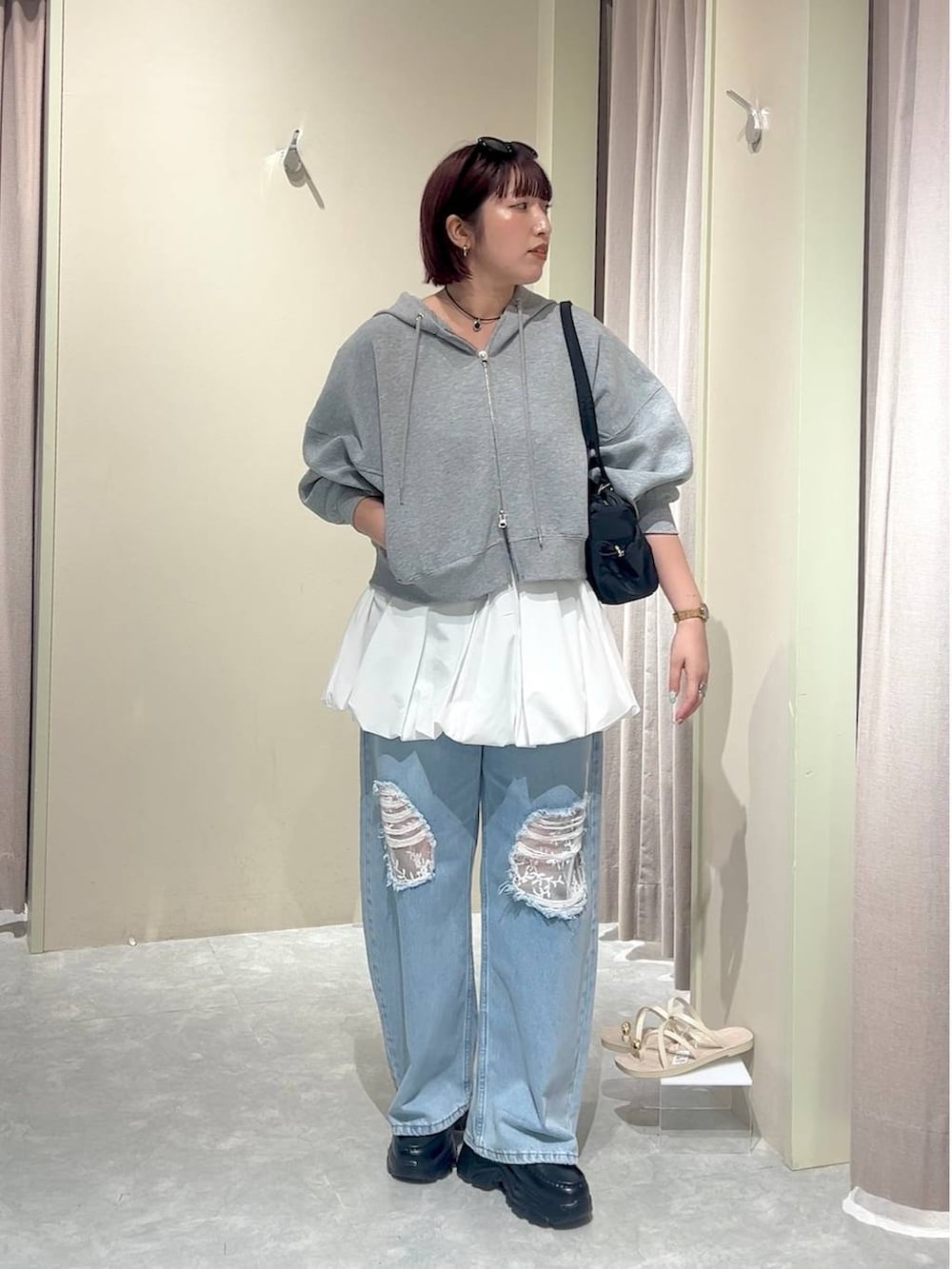 グレー系のパーカー、ブルー系のデニムパンツ、ブラック系のローファーを着用したレディースの秋コーディネートの5枚目の写真