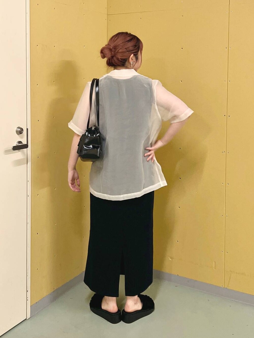 ブラック系のサンダル、ブラック系のボストンバッグ、ホワイト系のシャツ/ブラウスを着用したレディースの夏コーディネートの3枚目の写真