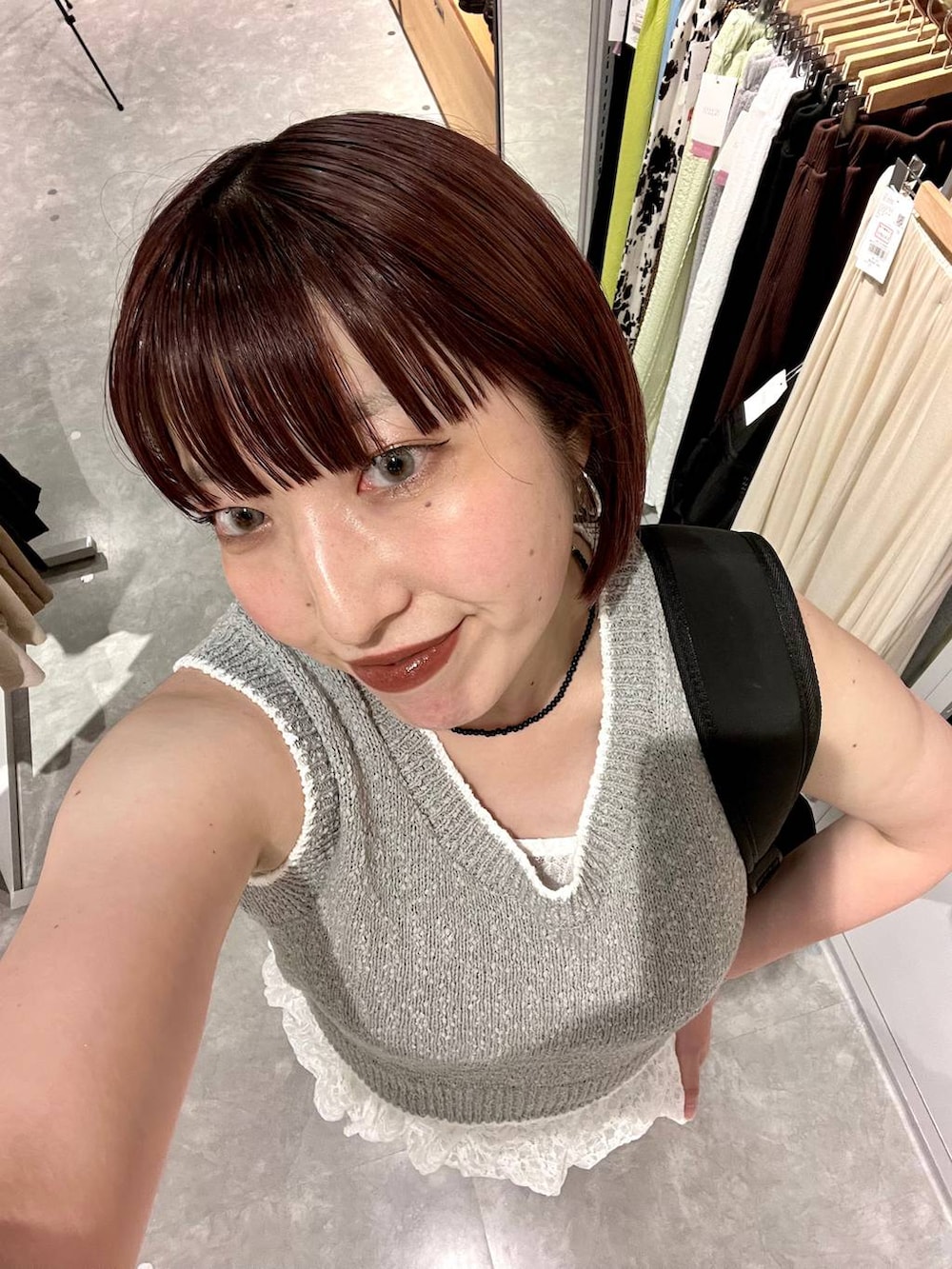 ブルー系のデニムパンツ、ブラック系のサンダル、グレー系のベストを着用したレディースの夏コーディネートの3枚目の写真