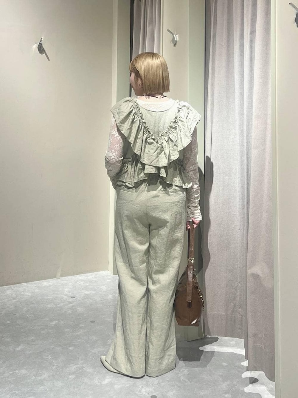 ブラウン系のショルダーバッグ、ホワイト系のパンプス、ホワイト系のTシャツ/カットソーを着用したレディースの春コーディネートの3枚目の写真