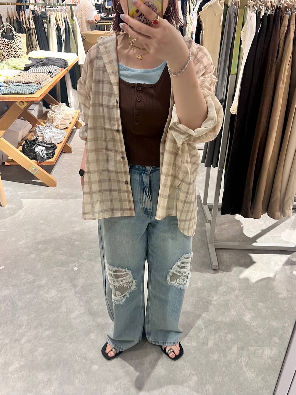 ブルー系のデニムパンツ、ベージュ系のシャツ/ブラウス、ブラック系のサンダルを着用したレディースの夏コーディネートの3枚目の写真