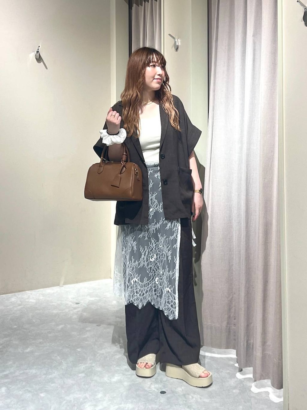 ホワイト系のTシャツ/カットソー、ホワイト系のサンダル、ブラウン系のテーラードジャケットを着用したレディースの秋コーディネートの4枚目の写真