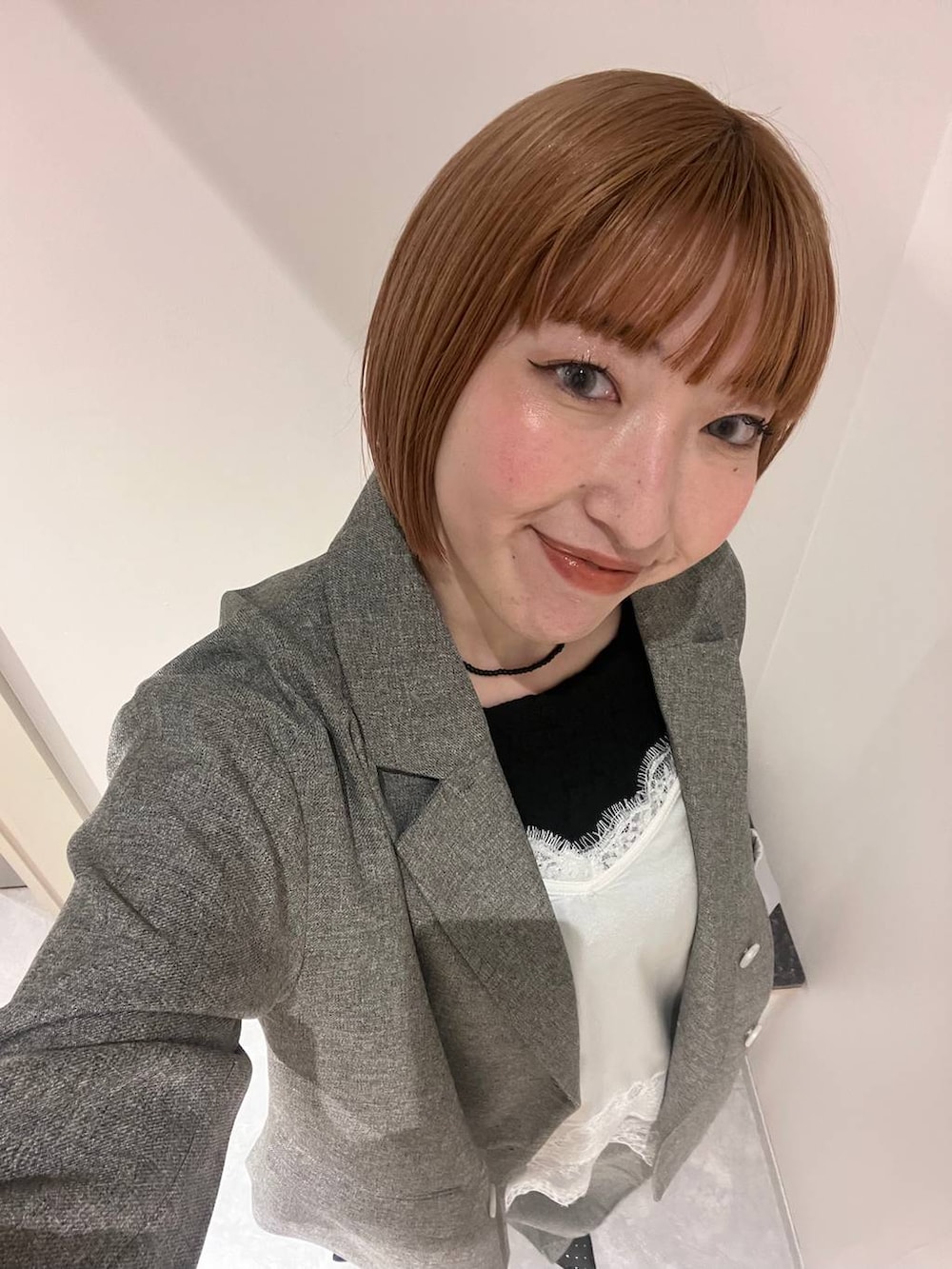 ブラック系のパンプス、グレー系のテーラードジャケット、グレー系のデニムパンツを着用したレディースの春コーディネートの3枚目の写真