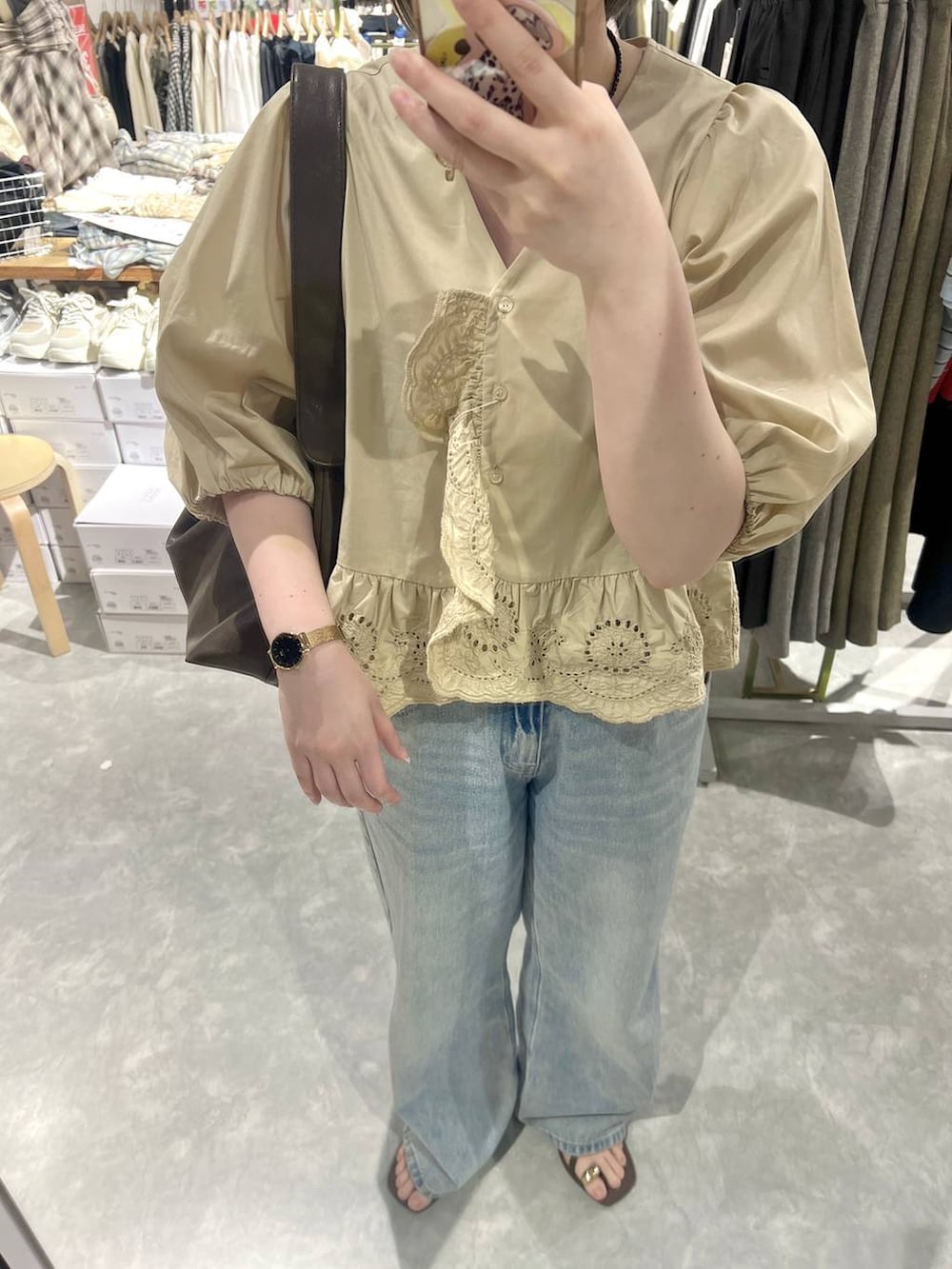 ブルー系のデニムパンツ、ブラウン系のサンダル、ベージュ系のシャツ/ブラウスを着用したレディースの春コーディネートの4枚目の写真