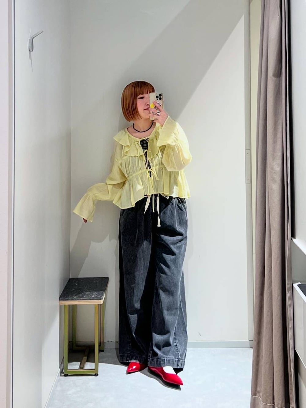 レッド系のパンプス、ブラック系のデニムパンツ、ブラウン系のタンクトップを着用したレディースの春コーディネートの2枚目の写真