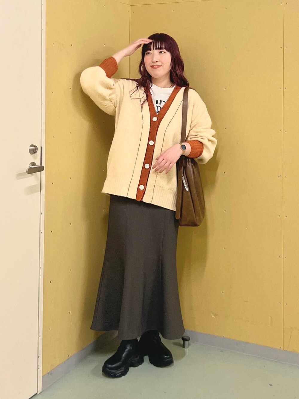 ブラック系のブーツ、ブラウン系のショルダーバッグ、グレー系のスカートを着用したレディースの冬コーディネートの3枚目の写真