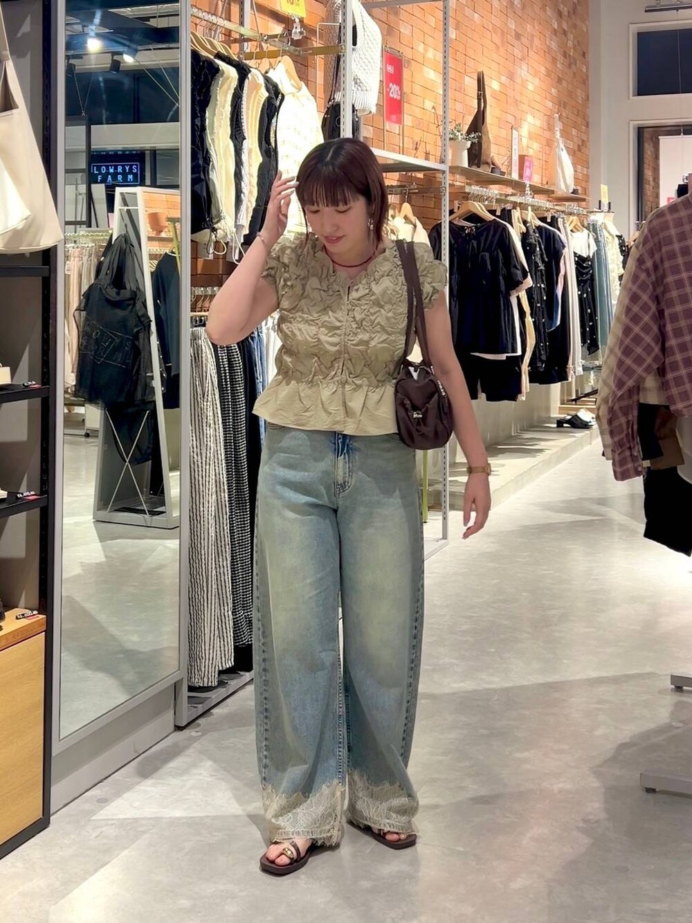 ベージュ系のシャツ/ブラウス、ブルー系のデニムパンツ、ブラウン系のサンダルを着用したレディースの夏コーディネートの3枚目の写真