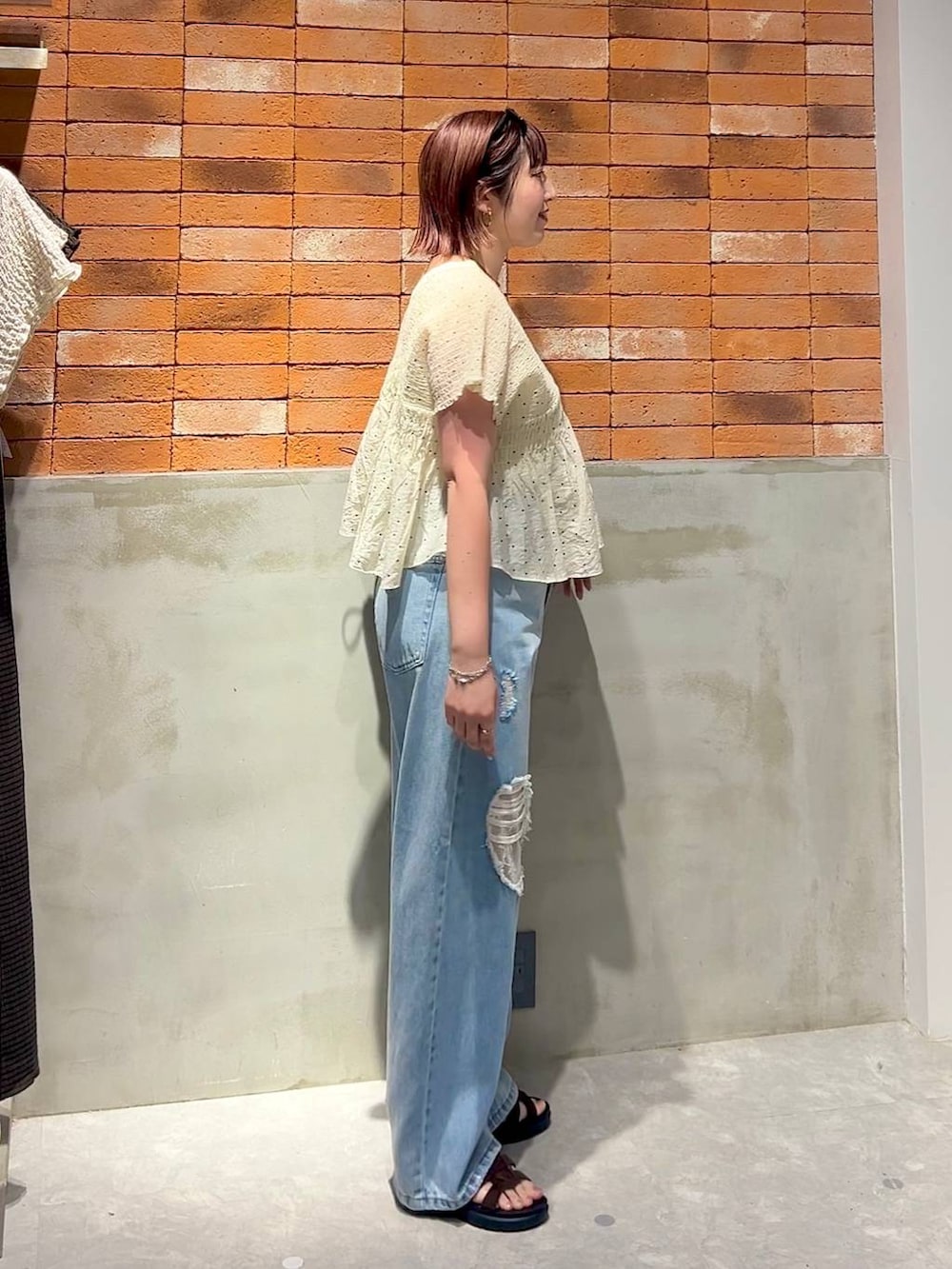 ブルー系のデニムパンツ、ブラウン系のサンダル、その他のシャツ/ブラウスを着用したレディースの夏コーディネートの2枚目の写真