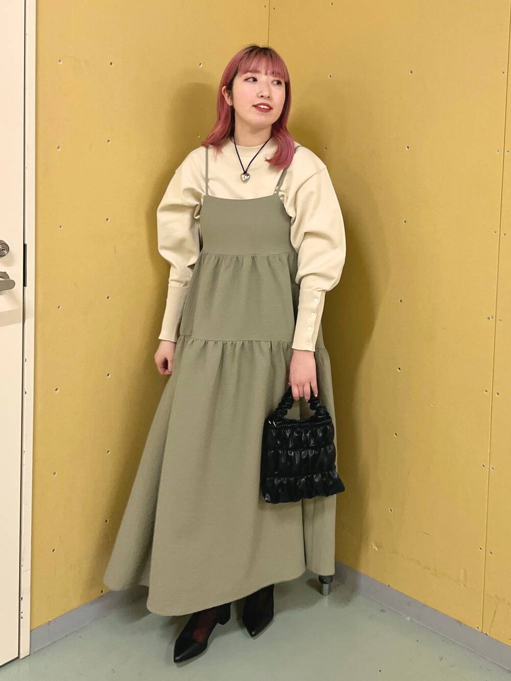 ブラック系のブーツ、ホワイト系のニット/セーター、ブラック系のショルダーバッグを着用したレディースの冬コーディネートの5枚目の写真