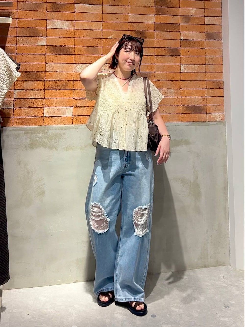 ブルー系のデニムパンツ、ブラウン系のサンダル、その他のシャツ/ブラウスを着用したレディースの夏コーディネートの3枚目の写真