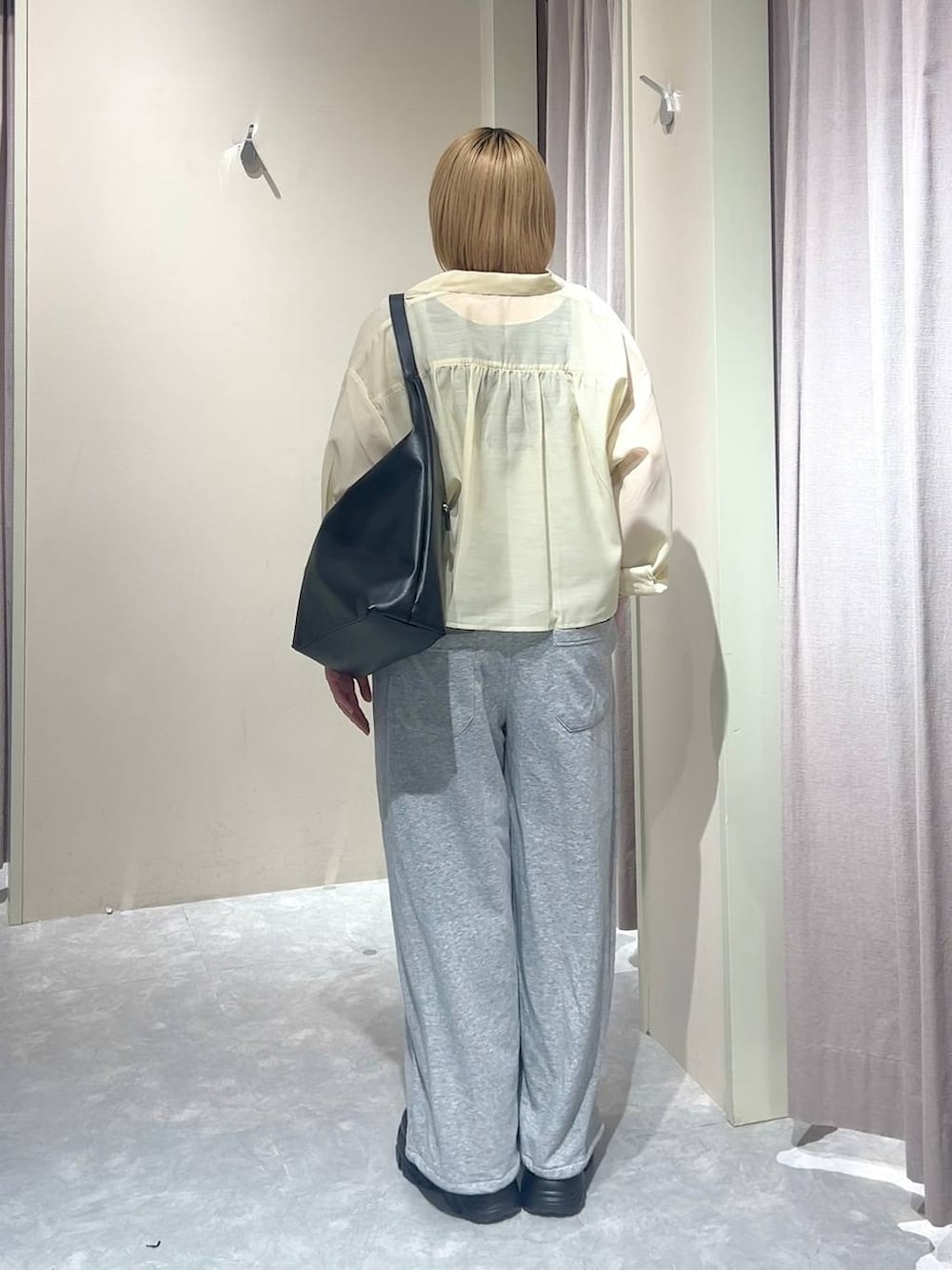 ブラック系のショルダーバッグ、イエロー系のシャツ/ブラウス、ブラック系のローファーを着用したレディースの春コーディネートの2枚目の写真