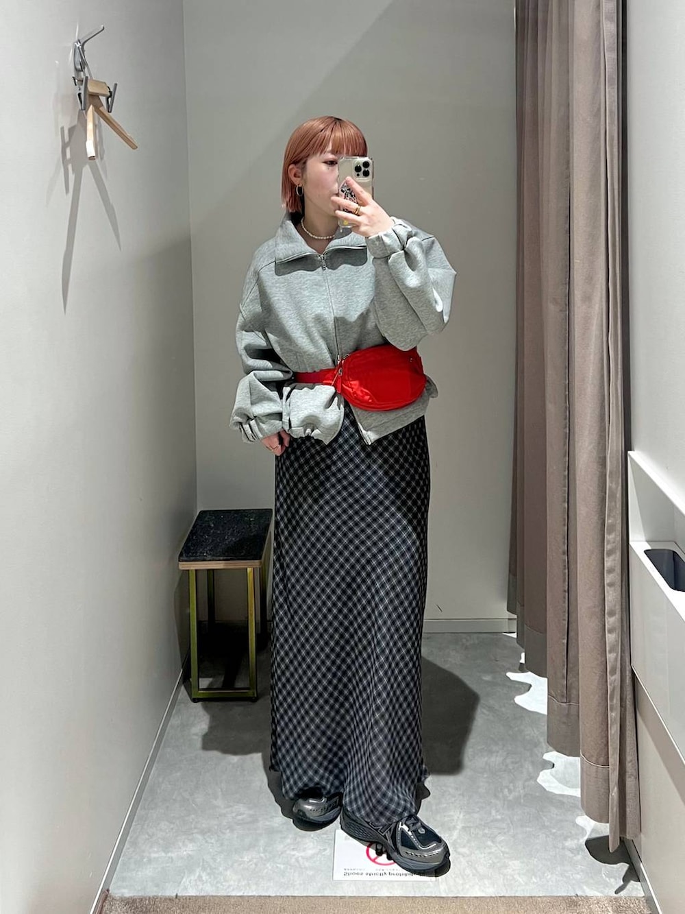 レッド系のボディバッグ/ウエストポーチ、グレー系のスカート、グレー系のスウェットを着用したレディースの冬コーディネートの6枚目の写真