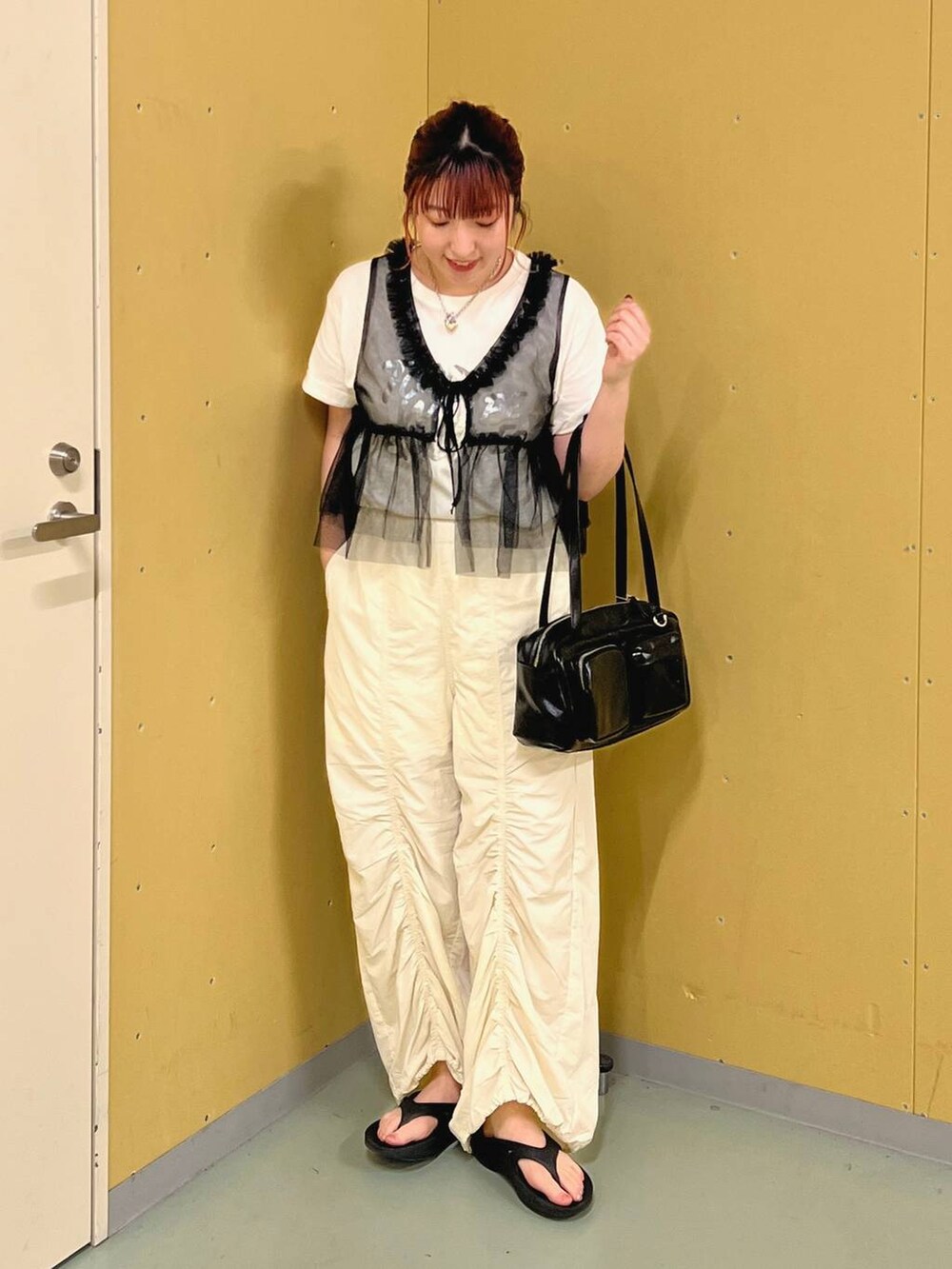 ホワイト系のカーゴパンツ、ブラック系のシャツ/ブラウス、ブラック系のサンダルを着用したレディースの夏コーディネートの4枚目の写真