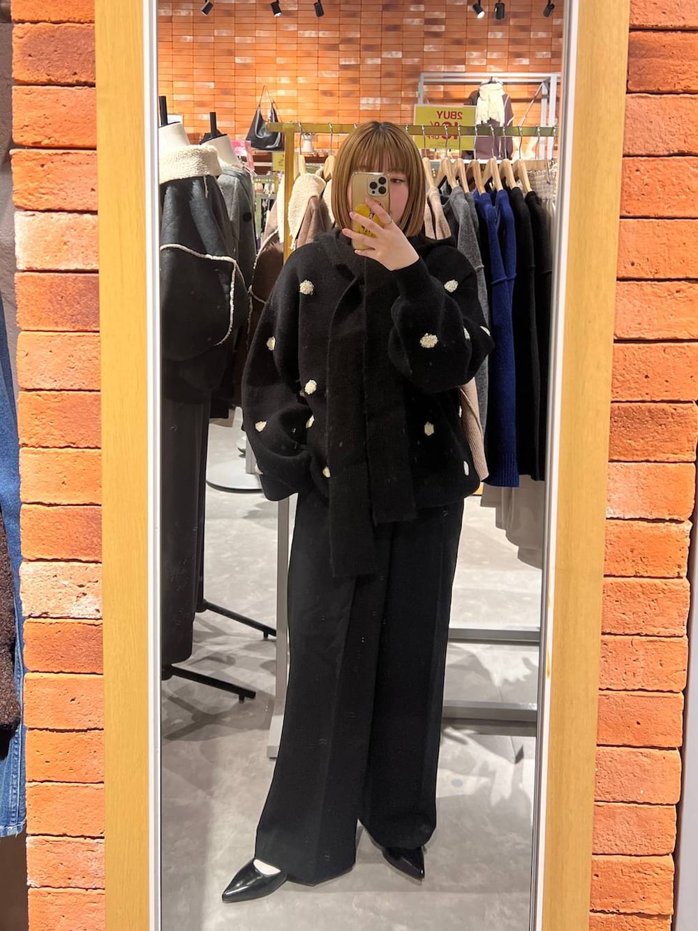 ブラック系のスラックス、ブラック系のパンプス、ブラック系のニット/セーターを着用したレディースの冬コーディネートの3枚目の写真