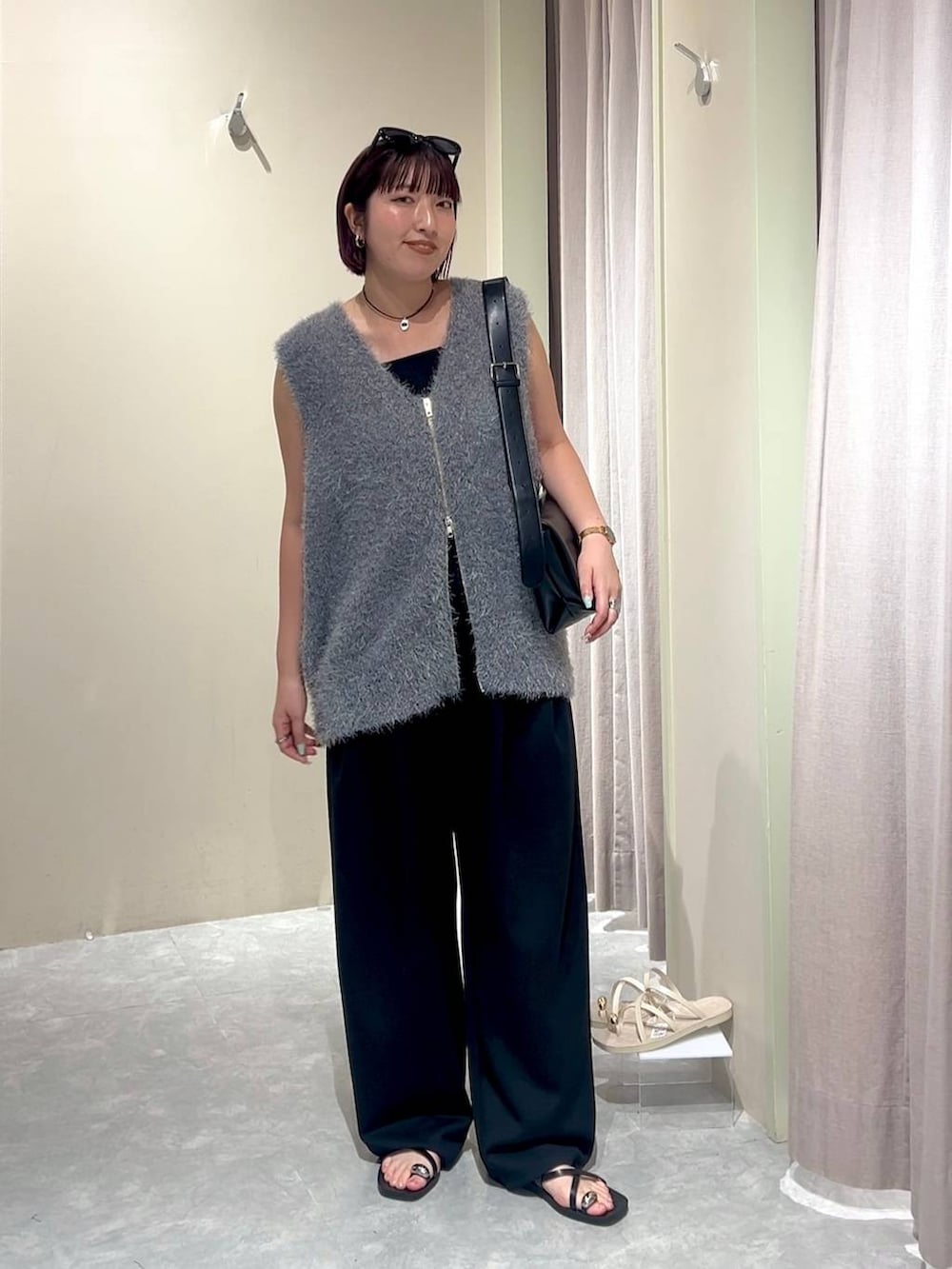 ブラック系のショルダーバッグ、ブラック系のスウェットパンツ、ブラック系のタンクトップを着用したレディースの秋コーディネートの8枚目の写真