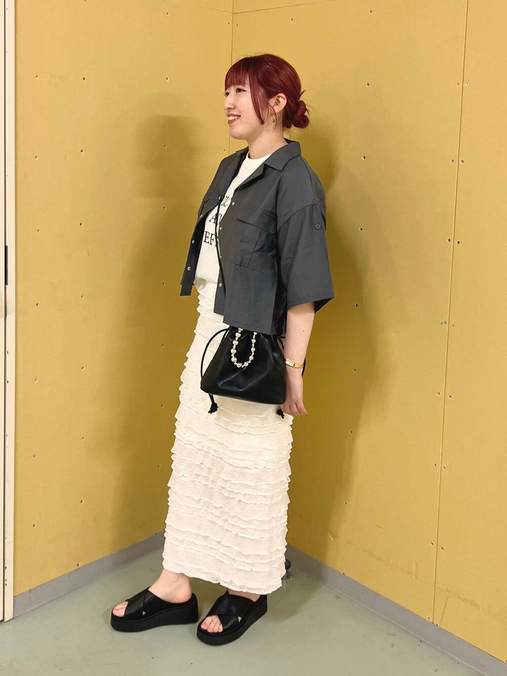 ホワイト系のスカート、グレー系のセットアップ、ブラック系のサンダルを着用したレディースの夏コーディネートの2枚目の写真