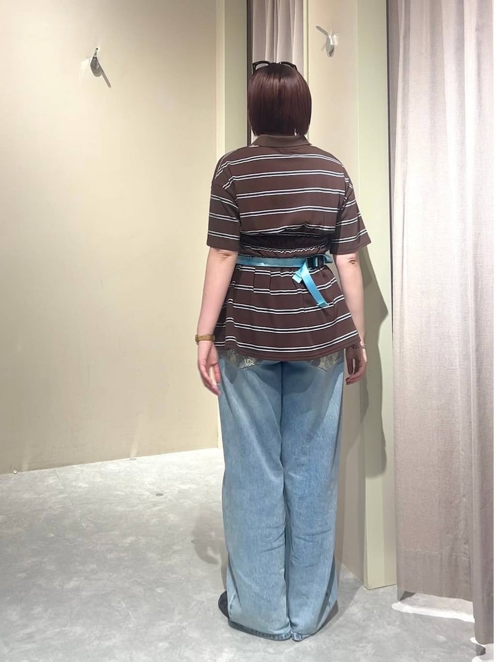 ブルー系のデニムパンツ、ブルー系のボディバッグ/ウエストポーチ、ブラウン系のローファーを着用したレディースの春コーディネートの3枚目の写真