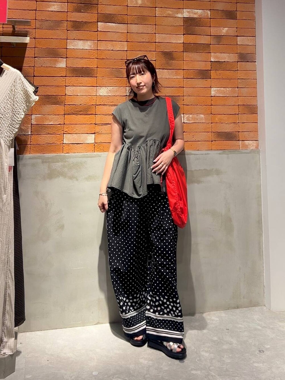 グレー系のTシャツ/カットソー、シルバー系のサンダル、レッド系のショルダーバッグを着用したレディースの夏コーディネートの5枚目の写真