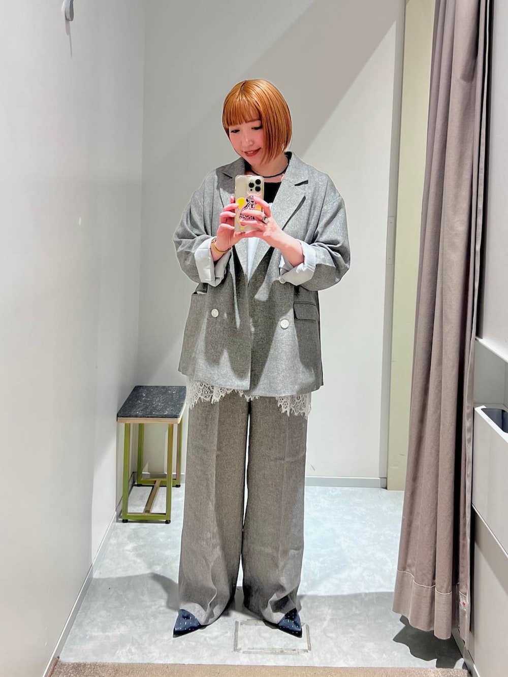 ブラック系のパンプス、グレー系のテーラードジャケット、グレー系のデニムパンツを着用したレディースの春コーディネートの4枚目の写真