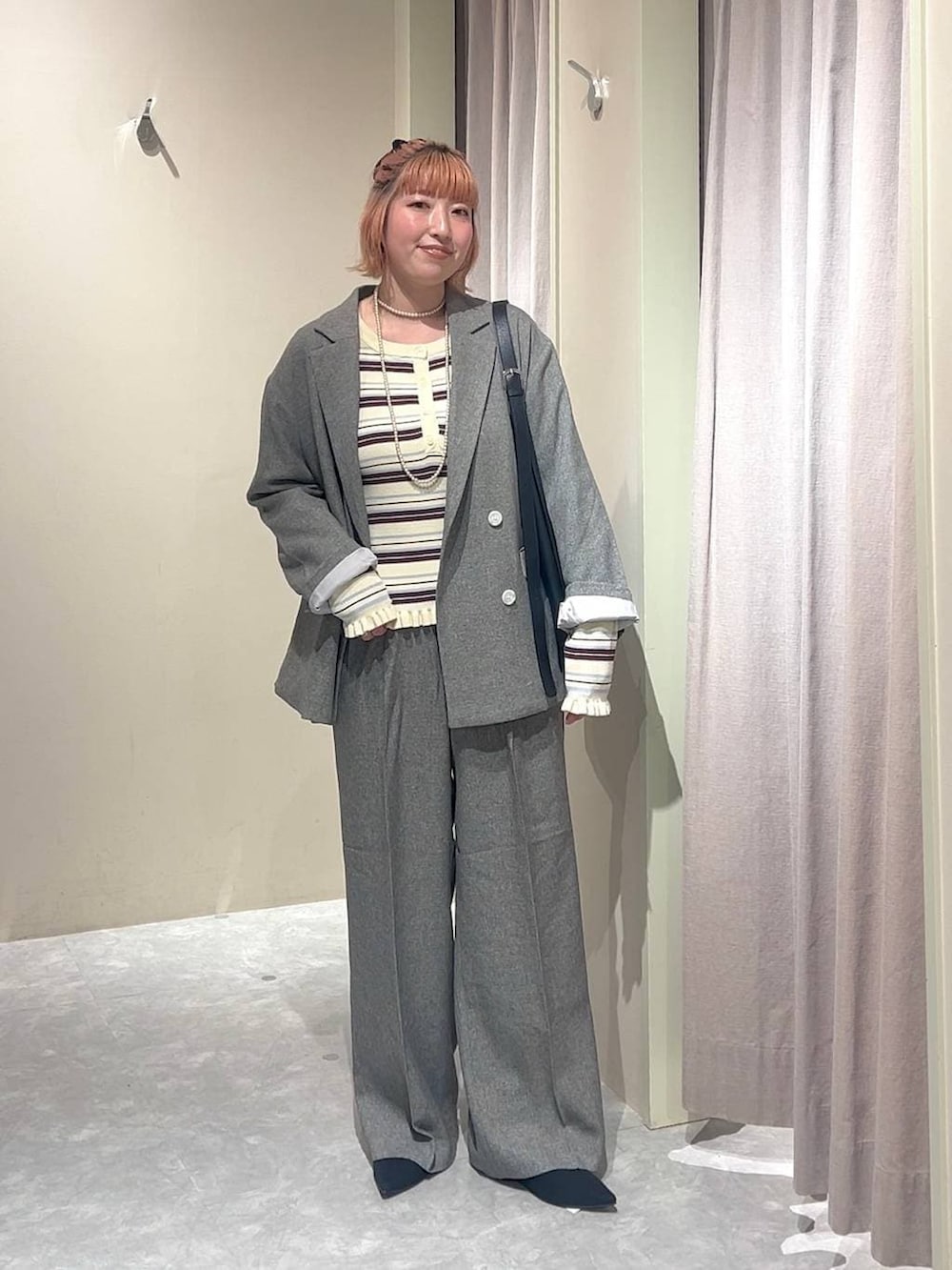 ブラック系のショルダーバッグ、グレー系のテーラードジャケット、グレー系のデニムパンツを着用したレディースの春コーディネートの4枚目の写真