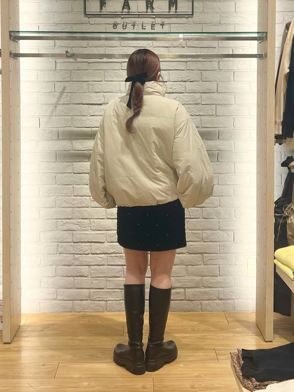 ホワイト系のその他アウター、ブラック系のブーツ、ブラック系のスカートを着用したレディースの冬コーディネートの3枚目の写真