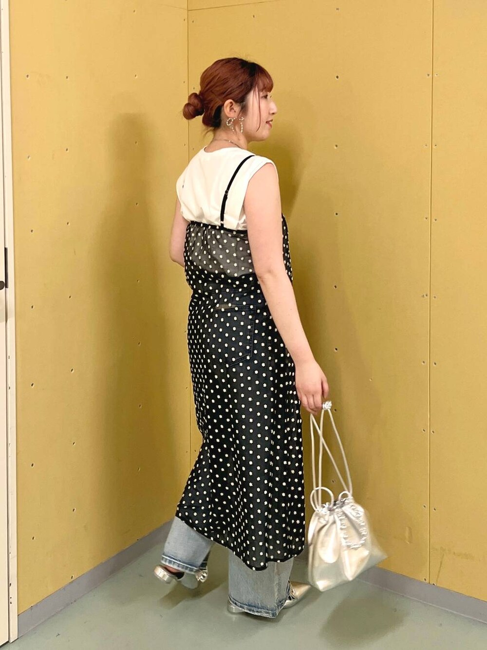 シルバー系のパンプス、シルバー系のショルダーバッグ、ブルー系のデニムパンツを着用したレディースの夏コーディネートの2枚目の写真