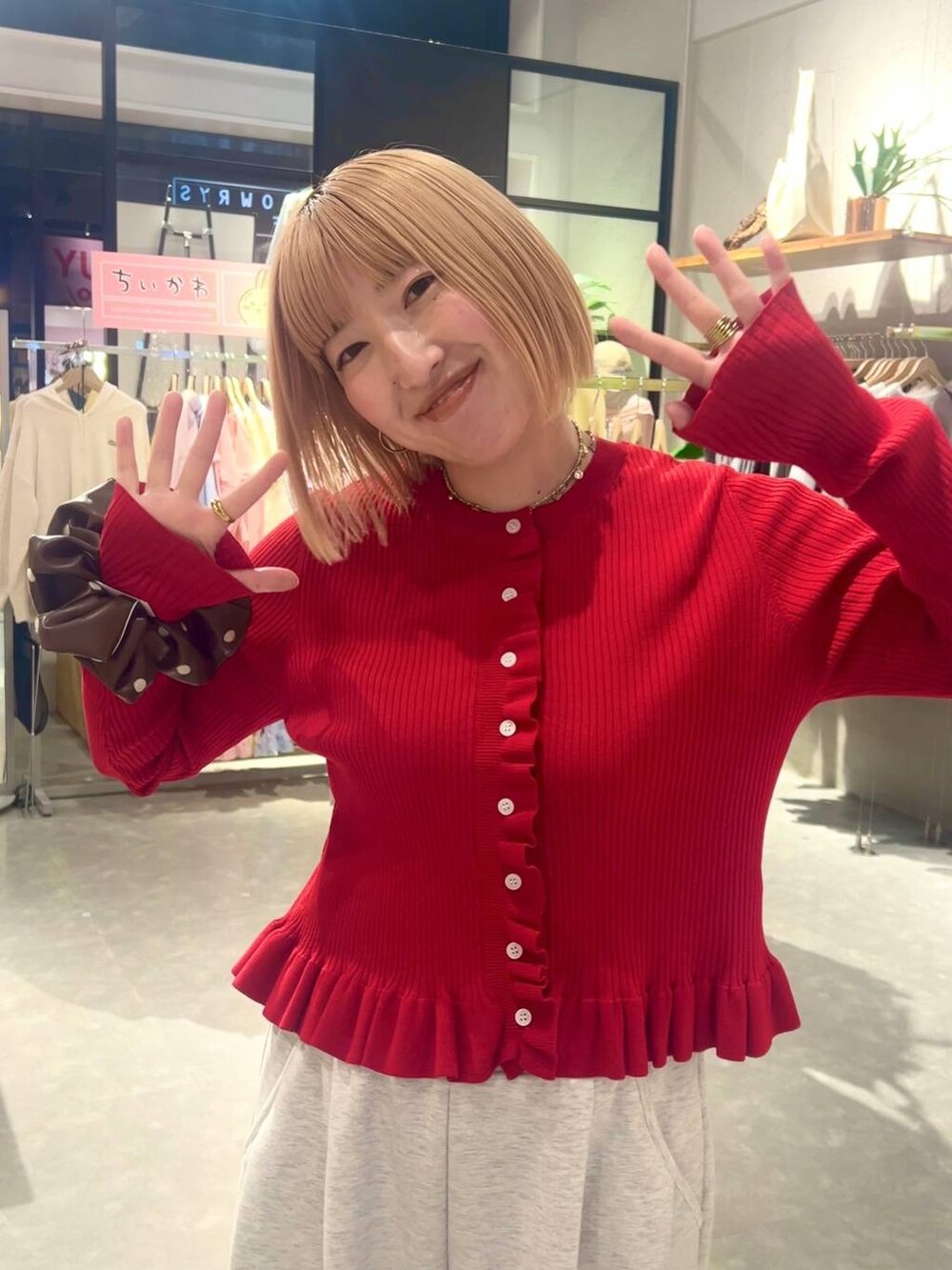 グレー系のスウェットパンツ、レッド系のTシャツ/カットソー、ブラウン系のヘアゴムを着用したレディースの冬コーディネートの4枚目の写真