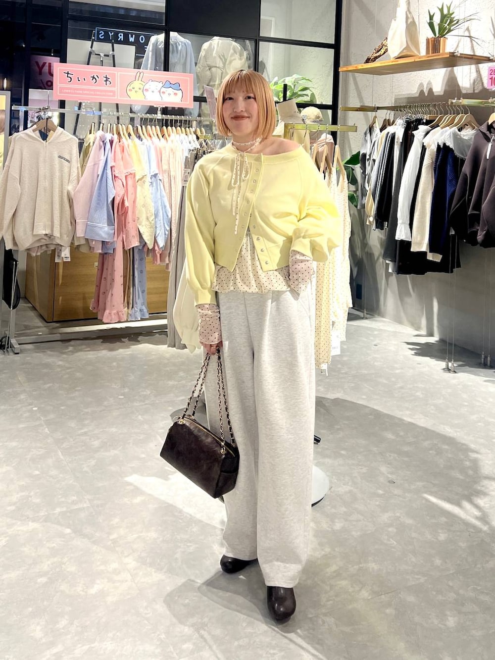 グレー系のスウェットパンツ、ブラウン系のショルダーバッグ、ブラウン系のサンダルを着用したレディースの冬コーディネートの3枚目の写真