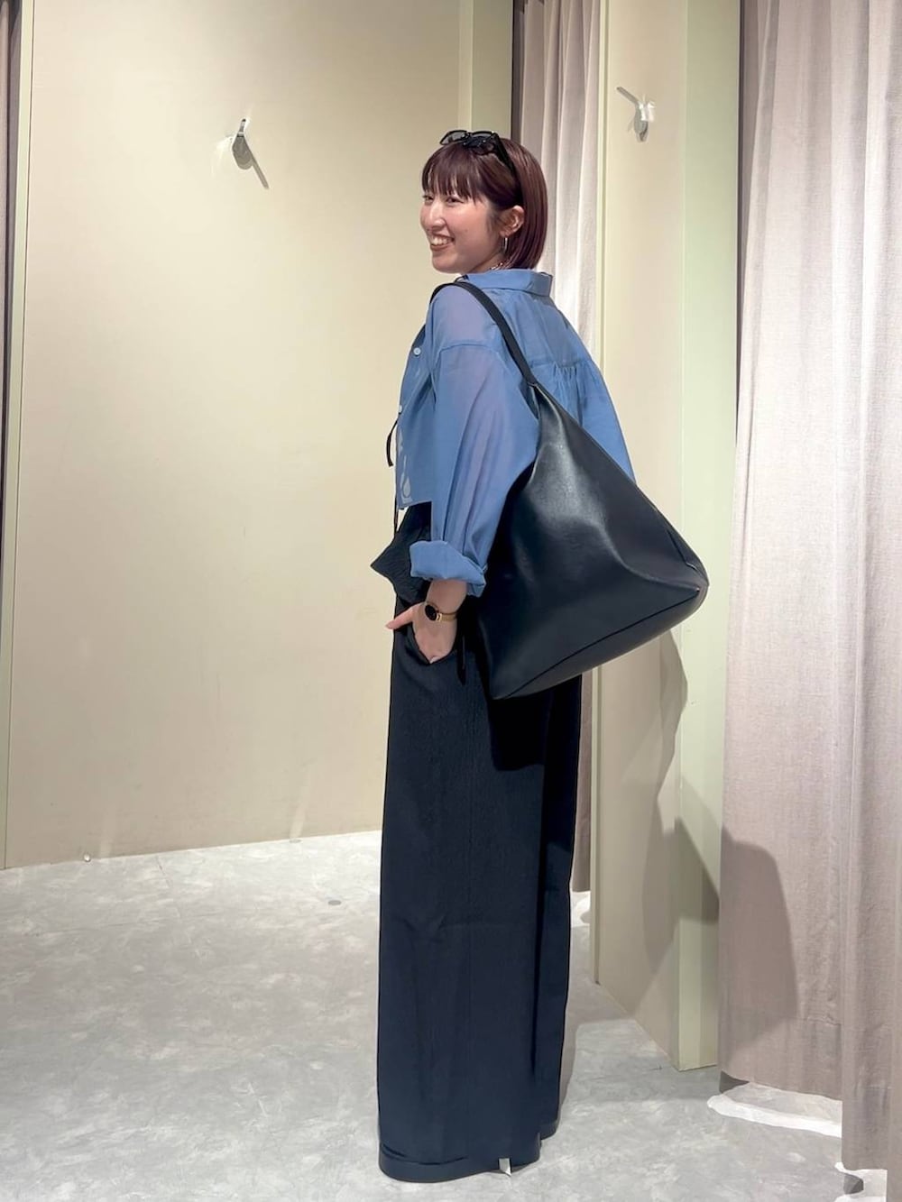 ブラック系のショルダーバッグ、ブルー系のシャツ/ブラウス、ブラック系のサンダルを着用したレディースの夏コーディネートの2枚目の写真