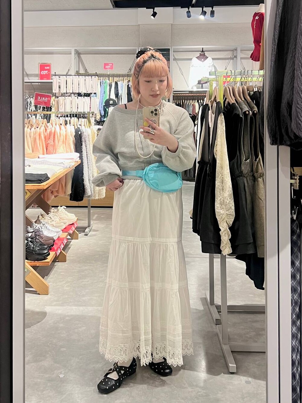 ブルー系のボディバッグ/ウエストポーチ、ブラック系のドレスシューズ、ホワイト系のスカートを着用したレディースの春コーディネートの3枚目の写真