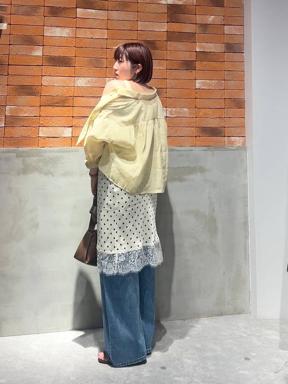 ゴールド系のタンクトップ、イエロー系のシャツ/ブラウス、ブルー系のデニムパンツを着用したレディースの夏コーディネートの4枚目の写真