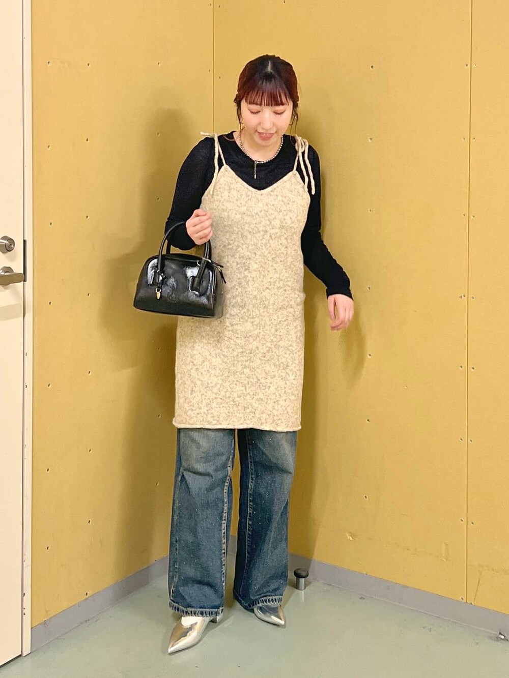 シルバー系のパンプス、ブルー系のデニムパンツ、ブラック系のTシャツ/カットソーを着用したレディースの秋コーディネートの5枚目の写真
